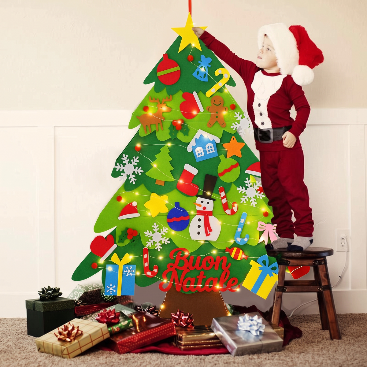 Bimbo vestito da Babbo Natale decora l'albero