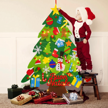 Bimbo vestito da Babbo Natale decora l'albero